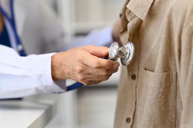 Arzt hört die Brust eines Patienten mit dem Stethoskop ab